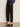 Model wears the Sanctuary Clothing ponte barrel trouser in black, paired with heeled mules. Image is cropped from the waist down, showing hands in pockets while standing on a plain floor.