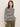 A woman models the Sanctuary Clothing boatneck long sleeve tee in light oat black stripe, standing against a plain background and looking slightly to the side with one hand in her pocket.