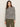 A woman with long brown hair wears the Sanctuary Clothing boatneck long sleeve tee in light oat black stripe, standing against a plain light background.
