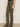 A person stands against a plain light wall, arms relaxed by their side, wearing Sanctuary Clothing's sculpted brook bootcut pant in kalamata and leopard print flats.