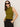 A woman with straight brown hair wears the "fuzzy shell martini olive" sleeveless turtleneck sweater by Sanctuary Clothing, paired with black sunglasses and pants, standing against a plain light background with hands in her pockets.