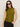 A woman with straight brown hair and black sunglasses wears the Sanctuary Clothing fuzzy shell martini olive sleeveless turtleneck sweater and black pants against a plain light background.