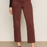 A person, visible from the waist down, stands against a light wall wearing Sanctuary Clothing's cadence 90s straight crop jeans in chicory and leopard print Mary Jane shoes.
