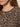 Close-up of a woman in Sanctuary Clothing's 24 7 Popover French Kitty top, featuring a brown and black leopard print. Only her lower face, neck, upper chest, and long brown hair over her shoulder are visible.