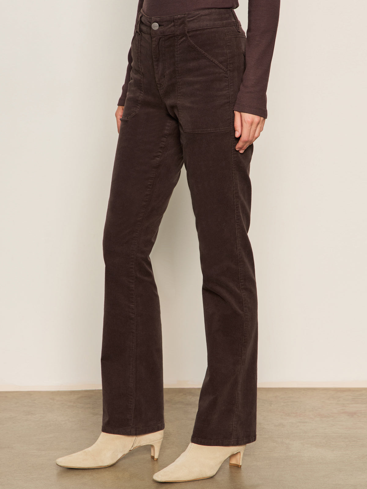 A person models Sanctuary Clothing's corduroy hayden bootcut pant in semi sweet, paired with beige ankle boots, standing against a neutral background with only their lower body visible.