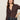 A woman with long brown hair models the Sanctuary Clothing Textured Knit Dreamgirl Top in Semi Sweet, a dark brown collared button-up, paired with high-waisted jeans. She poses with one hand on her hip against a plain background.
