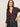 A woman with long brown hair models the Sanctuary Clothing Textured Knit Dreamgirl Top in Semi Sweet, a dark brown collared button-up, paired with high-waisted jeans. She poses with one hand on her hip against a plain background.