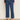 A person wearing Sanctuary Clothing's the marine jeans aspen—high-waisted, cropped blue jeans with front patch pockets—paired with a sheer black long-sleeve top and brown leopard-print flats stands against a neutral background.