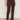A person wears Sanctuary Clothing's corduroy hayden bootcut pant semi sweet petites in dark brown with front patch pockets, paired with a white top and light beige shoes, standing against a plain background.