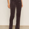 A person wears Sanctuary Clothing's corduroy hayden bootcut pant semi sweet petites in dark brown with front patch pockets, paired with a white top and light beige shoes, standing against a plain background.