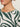 Close-up of a woman wearing Sanctuary Clothing's "the perfect tee green oasis extended sizing," featuring bold dark green abstract patterns on white. Only her chin, neck, and upper chest are visible against a plain light background.