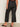A person is indoors with their back to the camera, showing only their lower half, wearing Sanctuary Clothing's the marine jeans after hours extended sizing.