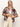 A woman with long blonde hair models the Sanctuary Clothing sanc souvenir shirt mesa palm—a short-sleeve brown shirt with a beige palm leaf design—layered over a white crop top and high-waisted cream pants against a light backdrop.