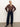 A person stands against a plain background, wearing the personal best blouse boheme by Sanctuary Clothing, paired with dark wide-leg jeans, a brown belt, and black heeled ankle boots. Their light hair is pulled back as they pose with relaxed confidence.
