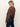 A woman with blonde hair in a low ponytail wears the Sanctuary Clothing personal best blouse boheme and dark denim jeans, standing sideways and looking down over her shoulder against a plain background.
