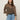 A woman with long brown hair models Sanctuary Clothing’s the adore blouse french kitty—a leopard print top with ruffled sleeves—paired with blue jeans, standing confidently against a plain light background.