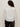 Seen from behind, a person with curly hair wears the Sanctuary Clothing new era tuxedo shirt white extended sizing and dark pants, standing against a plain light-colored background.