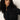 A woman with long, curly dark hair wears the Sanctuary Clothing new era tuxedo shirt in black and looks to her left with a neutral expression, set against a plain light background.
