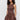 A woman with curly hair models the Sanctuary Clothing "take me away midi dress mesa"—a sleeveless, brown, fitted-top dress with a gathered skirt and pockets—standing against a plain background.