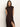 A woman with long brown hair models the autumns best sweater dress cocoa plaid by Sanctuary Clothing, featuring short sleeves, a diagonal plaid pattern, and a high slit, standing against a plain light background.
