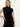 A woman with long blonde hair models the "an affair to remember dress black" by Sanctuary Clothing—a sleeveless, high-neck sequin dress—standing confidently against a plain white wall.