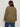 A woman with brown hair wearing sunglasses, blue jeans, and the Sanctuary Clothing barn jacket in burnt olive extended sizing stands with her back to the camera against a plain light background.