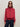 A person wears the Sanctuary Clothing satin track jacket in crimson, featuring white sleeve stripes, paired with dark sunglasses, hoop earrings, and dark jeans against a plain light background.