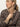 A woman with blonde hair in a low ponytail wears the Monroe Sateen Bomber Jacket French Kitty by Sanctuary Clothing, looking to her left and holding the collar with one hand against a neutral background.