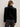 A person with long, light brown hair wears the Sanctuary Clothing quilted velvet jacket in black and dark jeans, standing with their back to the camera against a plain light background.
