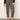 A person wears Sanctuary Clothing's Carnaby Kick Crop Legging Fluid Zebra pants with a black long-sleeve top and black low-heeled shoes, standing against a plain light background.
