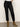 A person wears Sanctuary Clothing's the marine jeans after hours with tan suede heeled boots against a plain light wall, showing only their lower body.