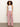 A woman with curly hair stands against a plain light background, wearing a white halter-top and Sanctuary Clothing's marine full length semi high rise pant galley stripe, styled with open-toe shoes.