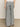 A person stands on a light floor, shown from the back, wearing Sanctuary Clothing’s marine full length semi high rise pant in yacht stripe—wide-leg pants with thin black and white vertical stripes, two back pockets, and a white top.