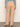 A person wearing Sanctuary Clothing's corduroy marine pant in dusty rose, paired with a textured light blue long-sleeve top and cream heeled shoes, stands against a neutral background.