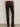 A person shown from the back wears Sanctuary Clothing’s Corduroy Hayden Bootcut Pant in Semi Sweet, featuring two flap back pockets, paired with black shoes and standing against a light wall.