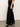 A person wears the Sanctuary Clothing runway ponte trouser in black, paired with pointed black ankle boots. Only their lower half is shown, standing on a gray floor against a plain light-colored wall.