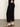 A person wearing the Sanctuary Clothing soft marine wide leg crop pant in black and black heeled sandals, with one hand on their hip, stands on a smooth indoor surface against a neutral background.