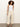 A woman with curly hair wears the Sanctuary Clothing soft marine wide leg crop pant macrame, a fitted white sleeveless top, and black heeled sandals, standing in a relaxed pose against a plain light background.