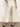 A person stands with their back to the camera, wearing Sanctuary Clothing's soft marine wide leg crop pant macrame in cream and black heeled sandals, set against a plain background.
