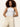 A woman with curly brown hair models Sanctuary Clothing’s soft marine wide leg crop pant macrame with a white sleeveless top, standing against a plain light background, hands in her pockets.
