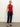 A woman with light hair tied back and a neutral expression wears Sanctuary Clothing's cadence 90s straight crop plot twist jeans, a sleeveless red collared striped top, and black flats against a plain light background.