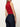 A woman stands with her back to the camera, wearing Sanctuary Clothing's cadence 90s straight crop plot twist jeans, paired with a sleeveless red mock-neck top featuring black stripes, set against a plain light background.