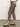 A person stands indoors with a hand in their pocket, wearing Sanctuary Clothing's cadence 90 straight crop jeans in french kitty. Only their body from the shoulders down is visible, paired with a white top and black low-heeled ankle-strap shoes.