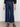 A person wears Sanctuary Clothing's league crop plot twist black textured long-sleeve shirt, paired with dark blue wide-leg jeans with front patch pockets and black strappy sandals, standing against a plain background.
