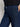 Wearing Sanctuary Clothing's league crop plot twist shirt, paired with high-waisted dark blue denim jeans featuring front patch pockets. The image shows the midsection and a hand resting on the hip.