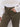 Wearing Sanctuary Clothing's league crop fatigue high-waisted, olive green jeans and a white, striped knit sweater, a person stands with one hand in their pocket.