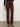 A person wearing Sanctuary Clothing's sculpted brook bootcut pant in chicory stands on a light gray floor against a plain off-white wall.