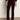A person indoors wears Sanctuary Clothing„¢s velveteen brook bootcut pant in dark crimson, paired with matching outerwear and heeled ankle boots. Only their lower half is visible against a plain background.