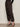 A person wearing Sanctuary Clothing's Sahara Satin Tapered Pant in Black stands against a light-colored wall, showing only the lower body.