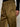 A close-up of a person wearing Sanctuary Clothing’s sahara satin tappered pant in Dirty Martini, highlighting the shiny olive-brown fabric, visible stitching, pocket details, and a black ribbed sweater sleeve.